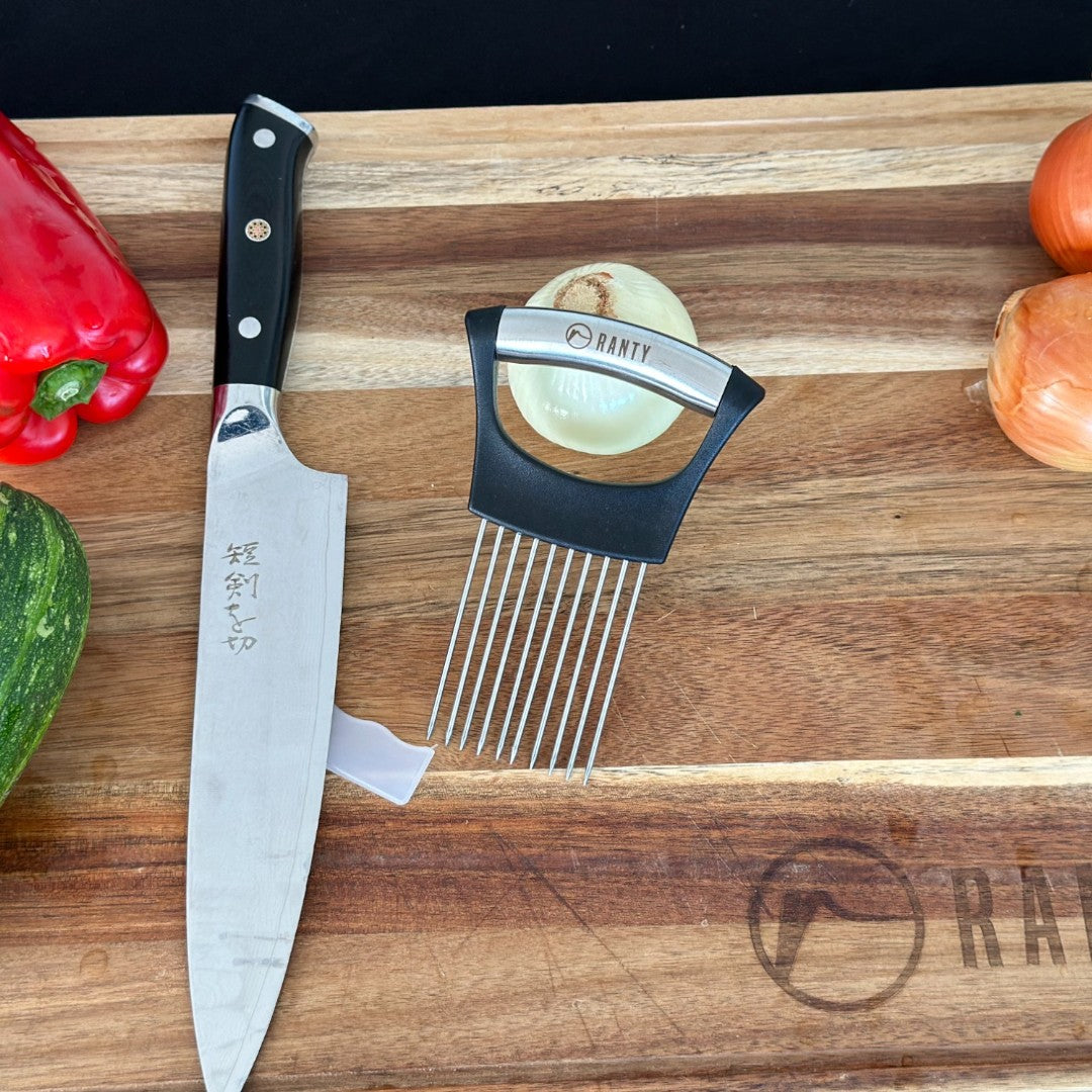 Guía para corte de carne y verduras Ranty junto a cuchillo chef sobre tabla de cocina.