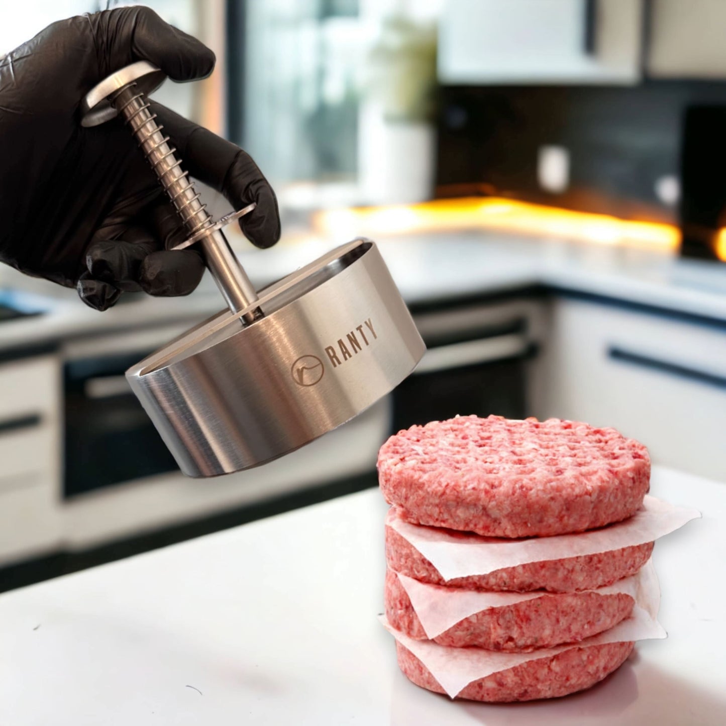 Prensa molde para hamburguesas Ranty de acero inoxidable en uso, demostrando preparación de hamburguesas caseras.