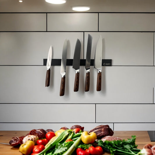 Soporte barra magnética metálica negra Ranty instalada en pared de cocina para organizar cuchillos y utensilios de cocina.