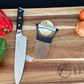 Guía para corte de carne y verduras Ranty junto a cuchillo chef sobre tabla de cocina.