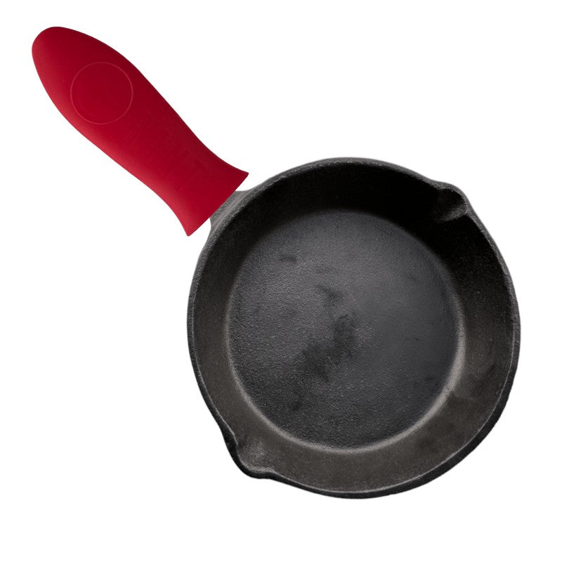 Mango de silicona para hierro fundido Ranty color rojo en uso sobre sartén de hierro fundido.