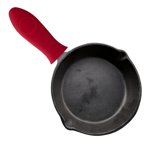 Mango de silicona para hierro fundido Ranty color rojo en uso sobre sartén de hierro fundido.
