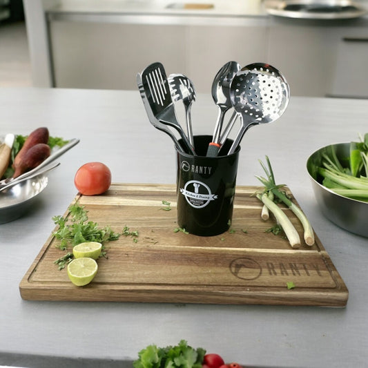 Set seis utensilios cocina Joven Ranty en balde sobre tabla madera con verduras frescas, diseño moderno y de acero inoxidable.
