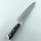 Cuchillo de acero de Damasco Grand Chef Ranty 20cm mostrando perfil de la hoja y mango negro.