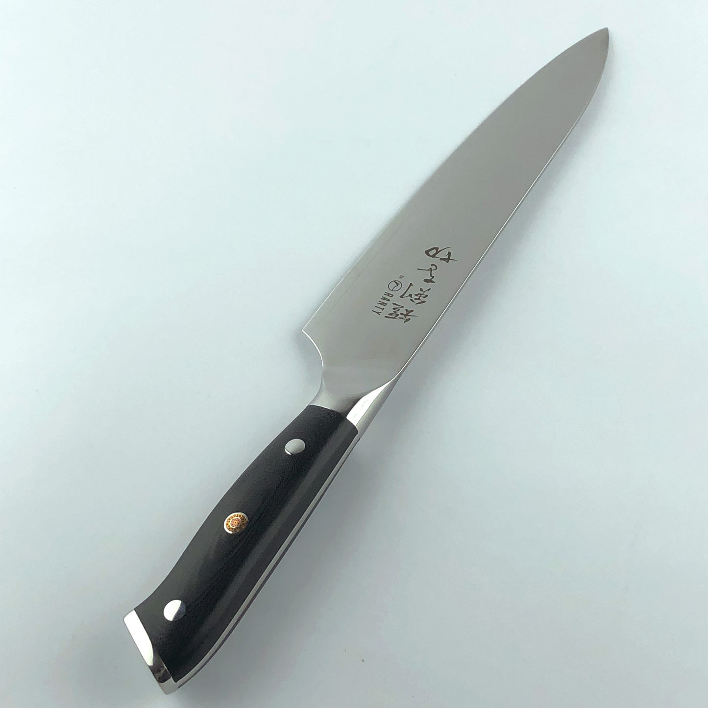 Cuchillo de acero de Damasco Grand Chef Ranty 20cm mostrando perfil de la hoja y mango negro.