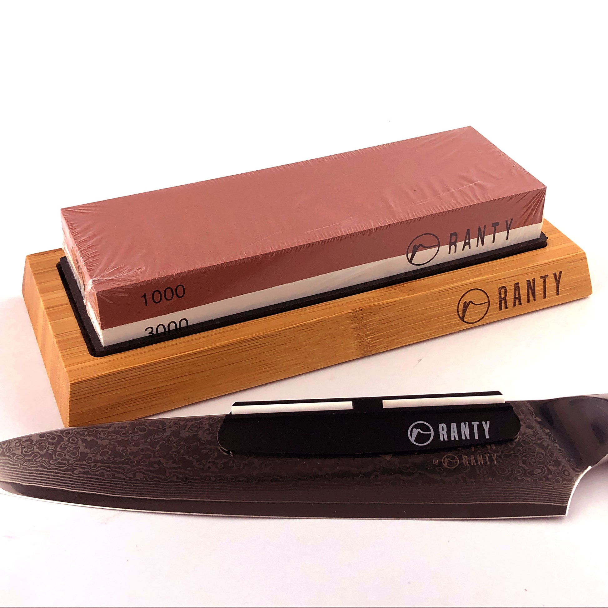 Kit afilador cuchillo piedra húmeda Ranty con cuchillo damasco junto a base de madera de silicón.
